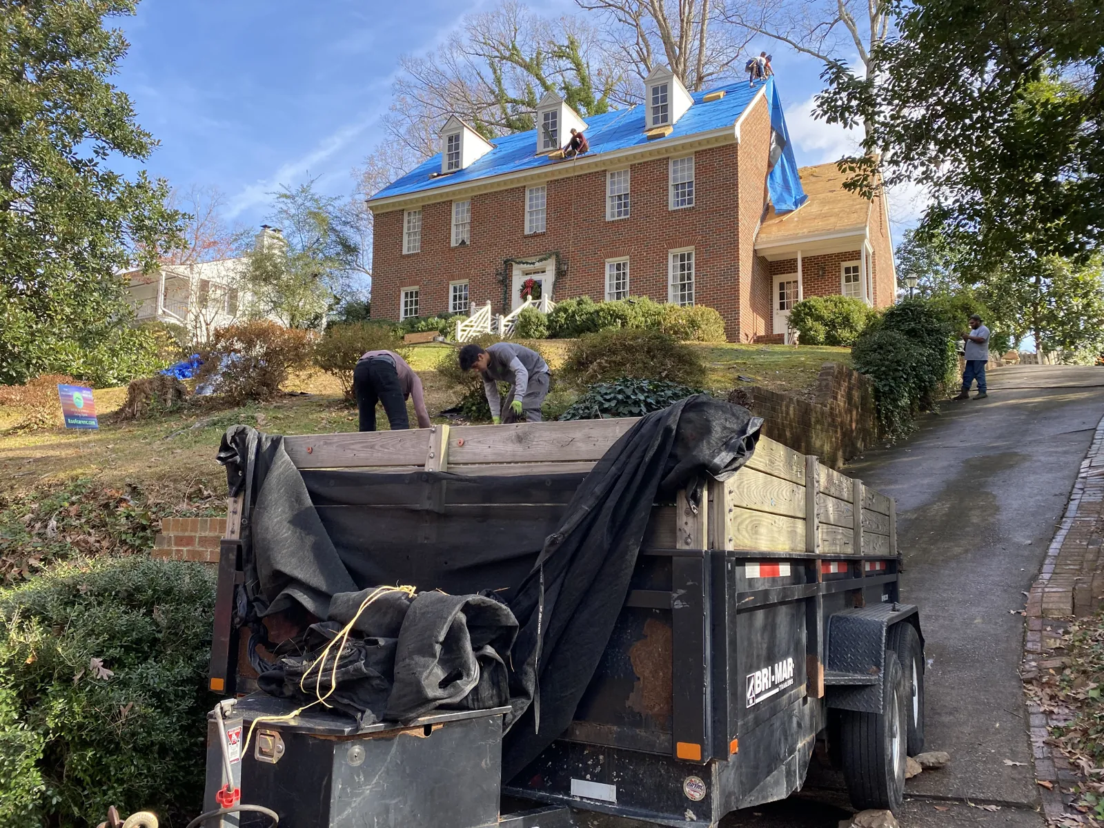 Blue emergency tarp installed on a storm-damaged roof