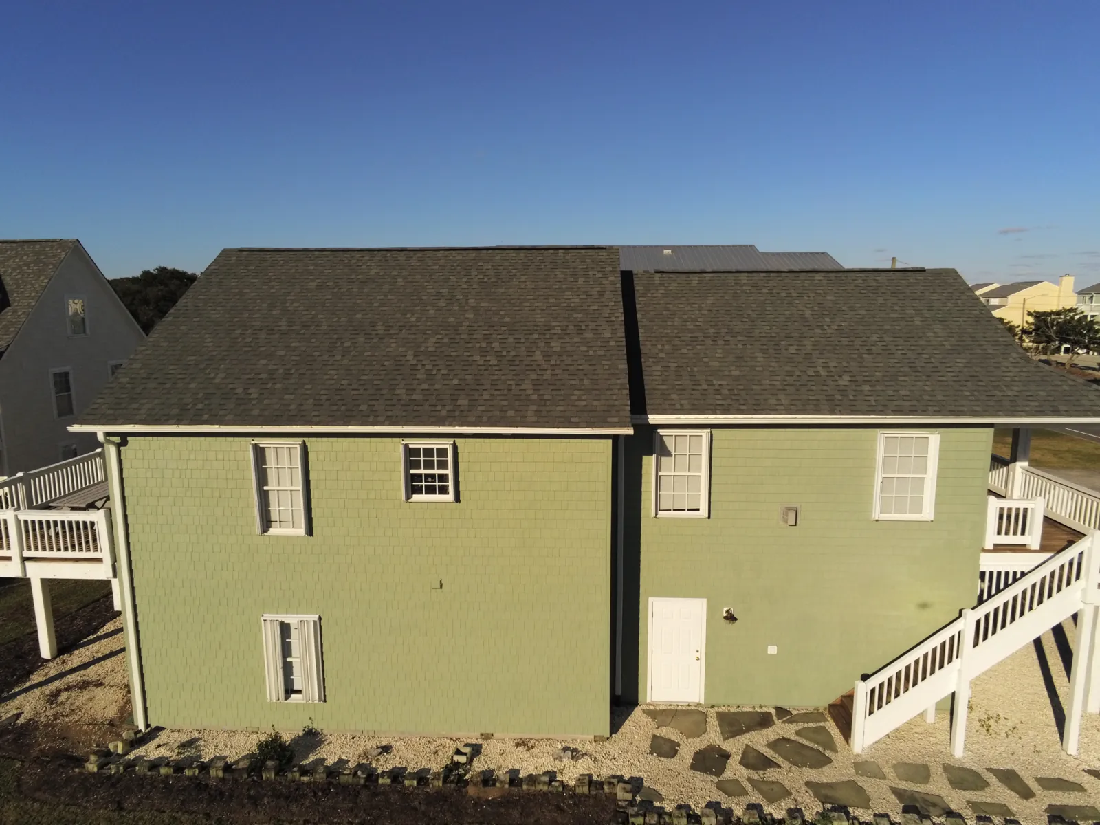 Two-story coastal home with a new asphalt shingle roof near the dunes in Eastern North Carolina