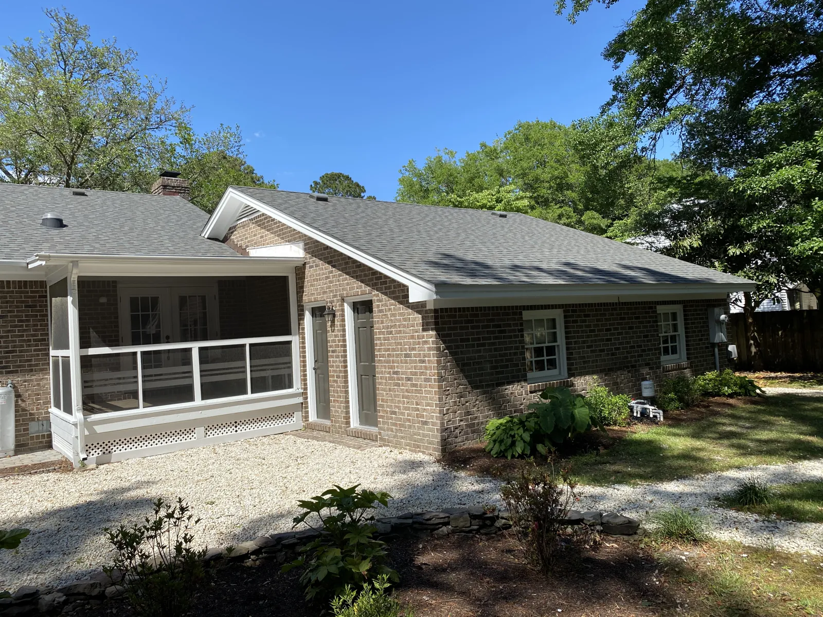 Completed GAF shingle roof on a brick ranch home surrounded by mature oaks in Eastern North Carolina