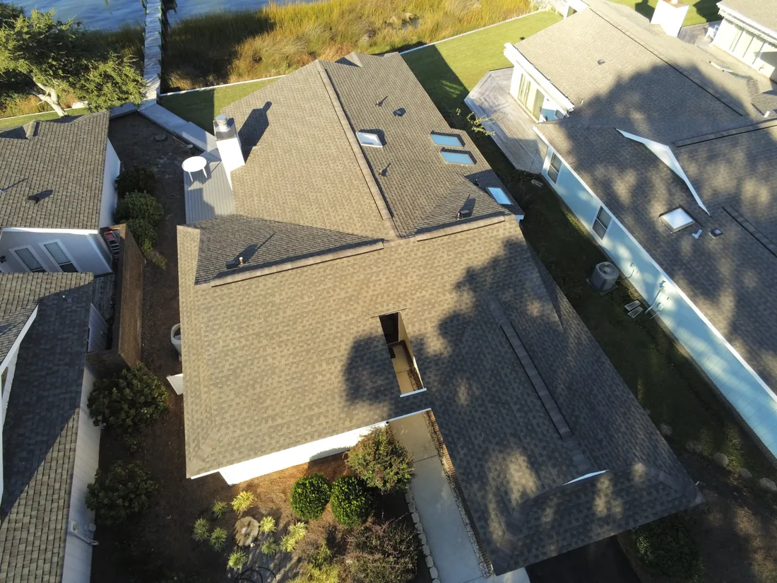 Aerial view of a completed asphalt shingle roof replacement on a suburban Eastern North Carolina home