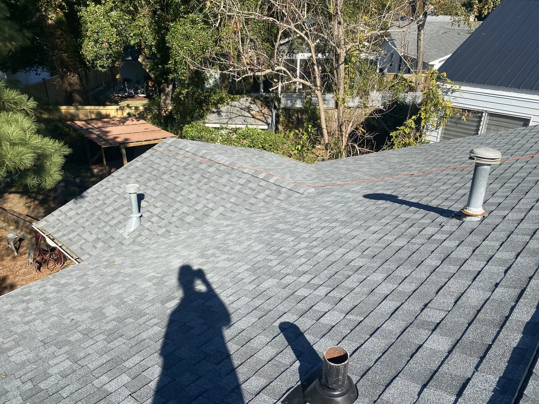 Newly installed asphalt shingle roof with fresh vent boots and pipe flashings