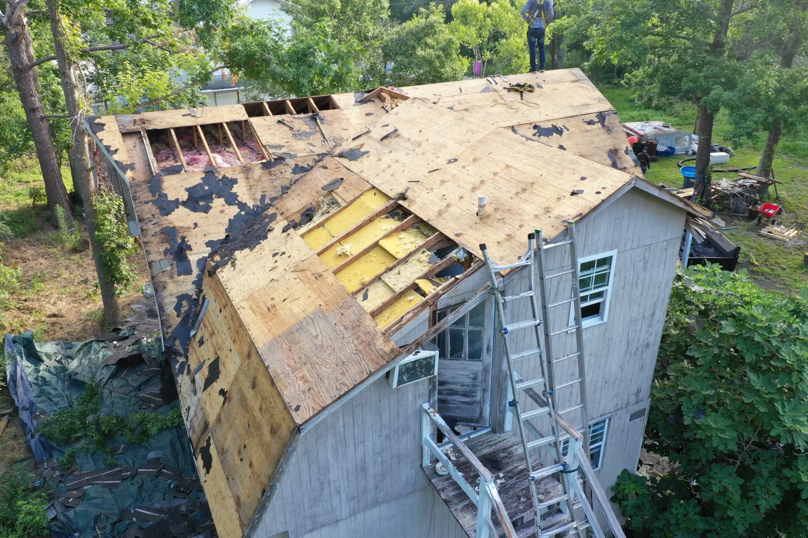 Storm-damaged roof torn down to the decking