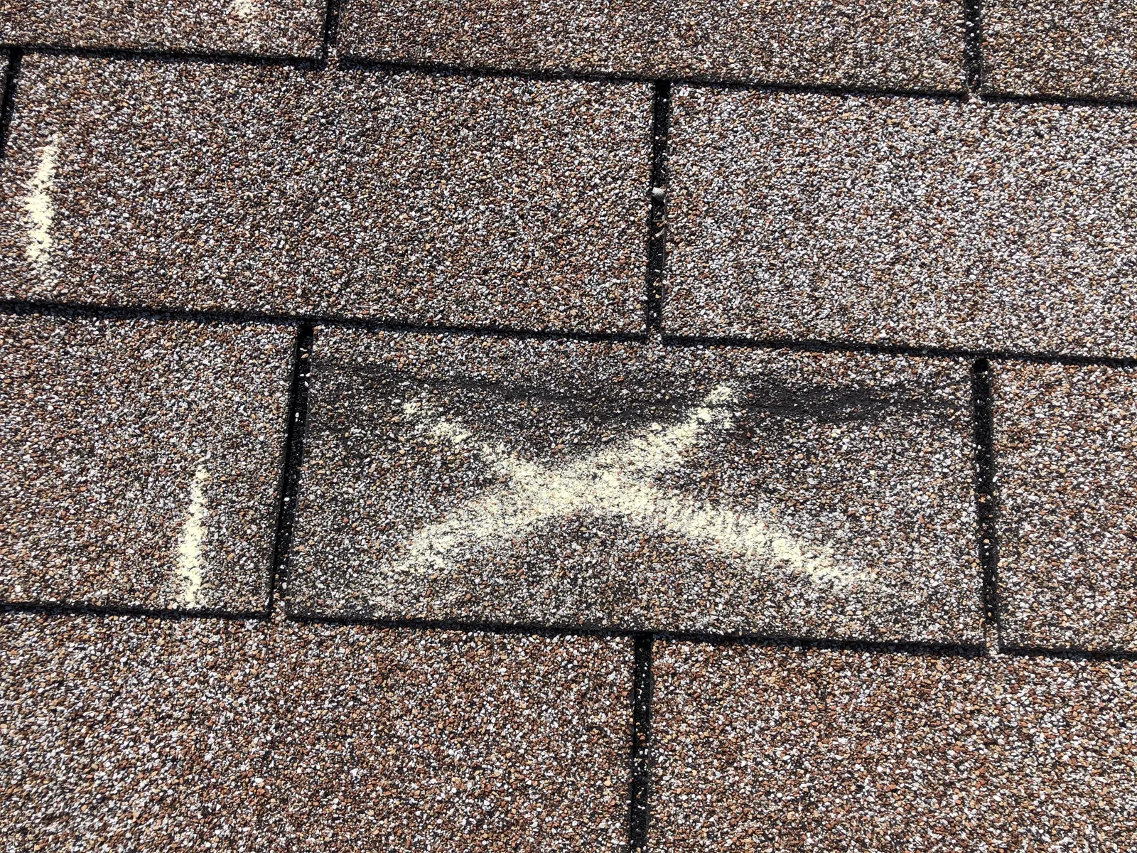 Hail strikes marked on an asphalt shingle roof
