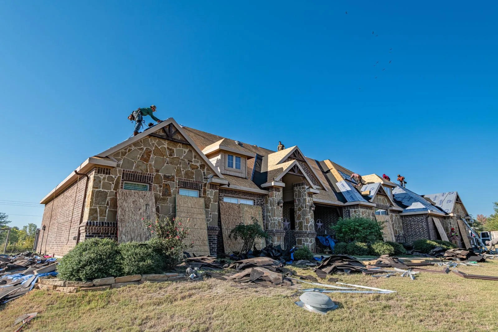 Roof replacement underway on a brick West Texas home after a hailstorm